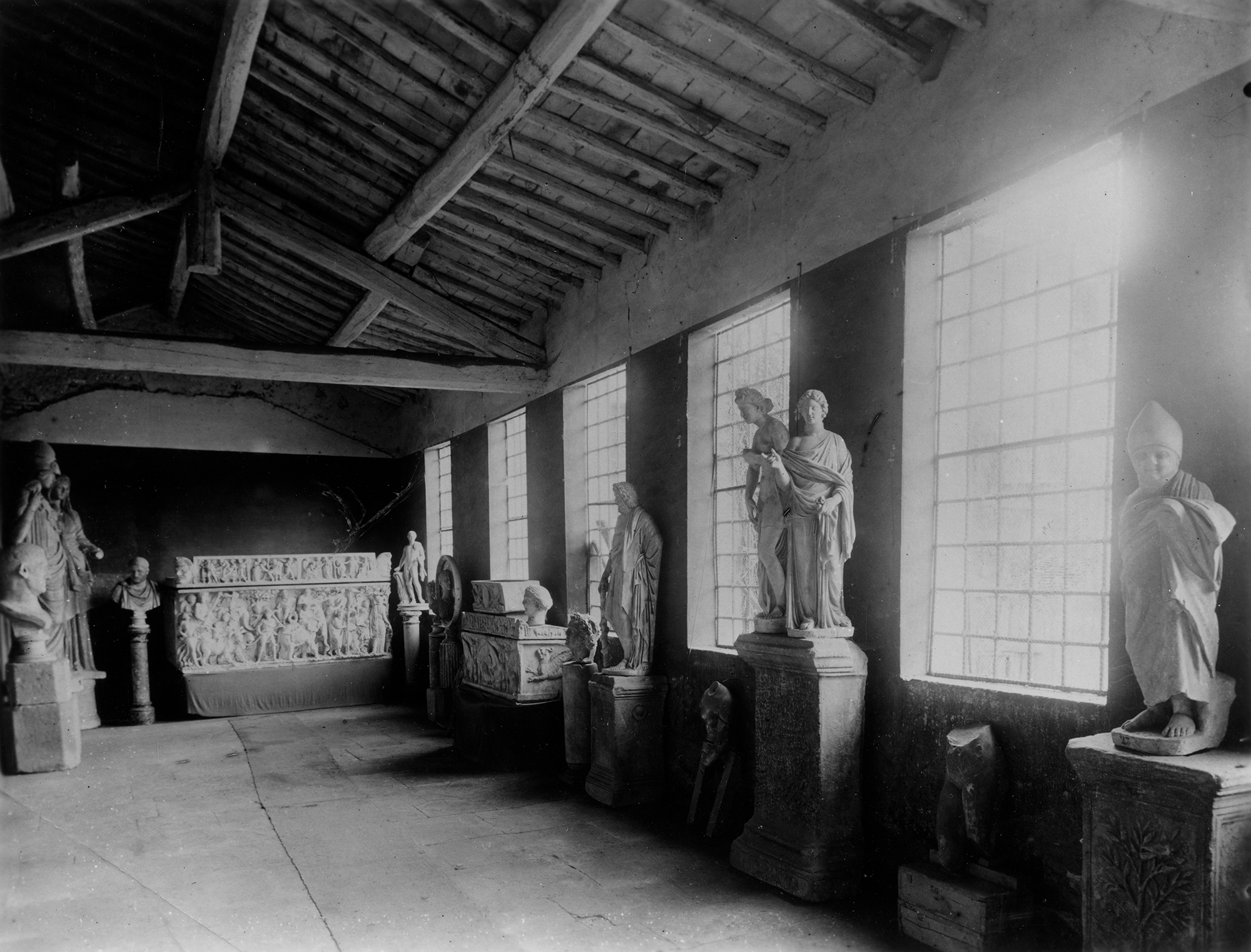 A ca. 1902 image of the marbles from the Massarenti collection as stored in the warehouse on the Via di Porta Angelica. The Sarcophagus for an Infant, acc. no. 23.162, is visible in this photo in front of the second window from left stacked on top of the Sarcophagus with Griffins, acc. no. 23.35